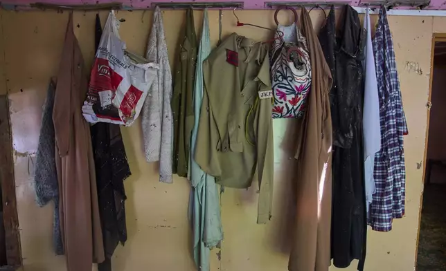 Naseer Ahmed's police uniform hangs on the wall of his house damaged by artillery shelling from Pakistan in the border village of Paranpillan, north of Srinagar, Indian-controlled Kashmir, Wednesday, May 14, 2025. (AP Photo/Dar Yasin)