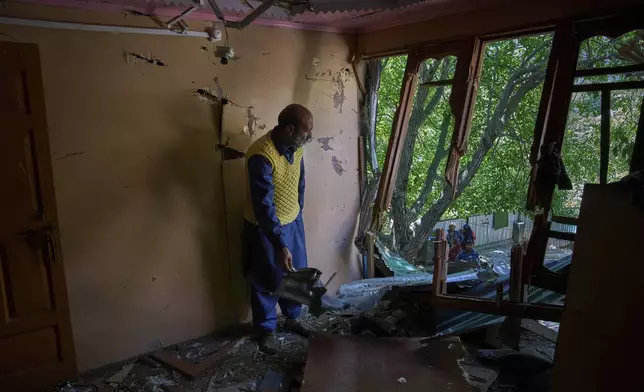 A policeman Naseer Ahmed inspects his house damaged by artillery shelling from Pakistan upon his return in the border village of Paranpillan, north of Srinagar, Indian-controlled Kashmir, Wednesday, May 14, 2025. (AP Photo/Dar Yasin)