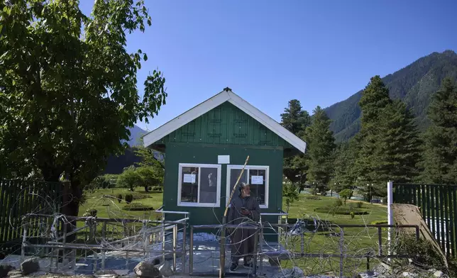 A Kashmiri man stands at the closed entrance of a park secured with barbed wires in Pahalgam in Indian controlled Kashmir, Thursday, May 16, 2025. (AP Photo/Dar Yasin)