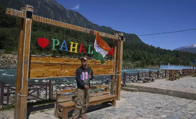 Arif Lone, an all-terrain vehicle owner, poses for a photograph with the Indian national flag at a deserted selfie point before participating in a Tiranga Yatra or tricolor march to highlight the success of Indian military Operation Sindoor, in Pahalgam, Indian controlled Kashmir, Thursday, May 16, 2025. (AP Photo/Dar Yasin)