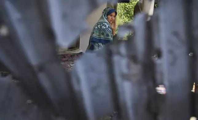 Shreena Begum is seen through the tin sheet of her hous, damaged by artillery shelling from Pakistan, in the border village of Gingal, north of Srinagar, Indian-controlled Kashmir, Wednesday, May 14, 2025. (AP Photo/Dar Yasin)