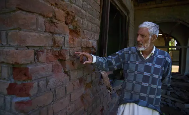 Mohammad Younis Khan shows the wall of his daughter's house that was damaged by artillery shelling from Pakistan, in the border village of Gingal, north of Srinagar, Indian-controlled Kashmir, Wednesday, May 14, 2025. (AP Photo/Dar Yasin)