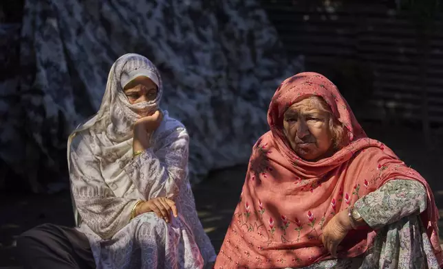 Misra Begum, left, and her mother-in-law Sayeeda Begum sit outside their house, which was damaged by artillery shelling from Pakistan, in the border village of Gingal, north of Srinagar, Indian-controlled Kashmir, Wednesday, May 14, 2025. (AP Photo/Dar Yasin)