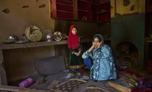 Shreena Begum and her daughter Safeena Banoo sit in their kitchen damaged by artillery shelling from Pakistan in the border village of Gingal, north of Srinagar, Indian-controlled Kashmir, Wednesday, May 14, 2025. (AP Photo/Dar Yasin)