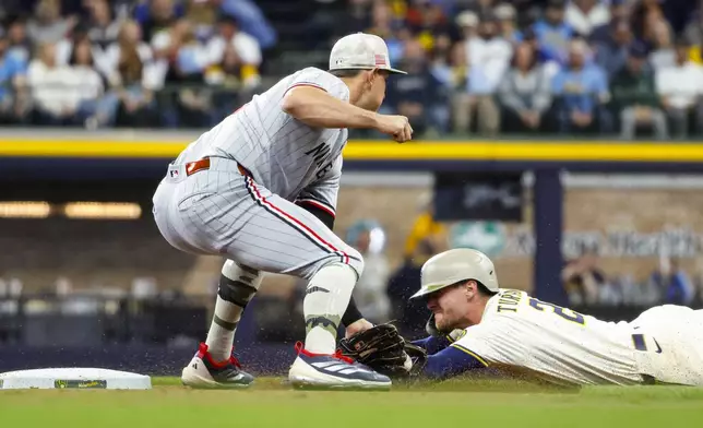 Milwaukee Brewers' Brice Turang steals second base ahead of the throw to Minnesota Twins' Brooks Lee during the first inning of a baseball game, Saturday May 17, 2025, in Milwaukee. (AP Photo/Jeffrey Phelps)