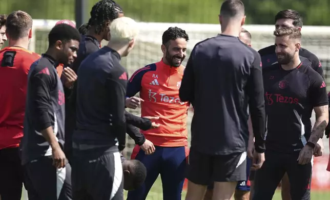 Manchester United's manager Ruben Amorim, center, smiles during a training session in Manchester, England, Tuesday May 20, 2025, ahead of the Europa League final soccer match between Tottenham and Manchester United (Martin Rickett/PA via AP)