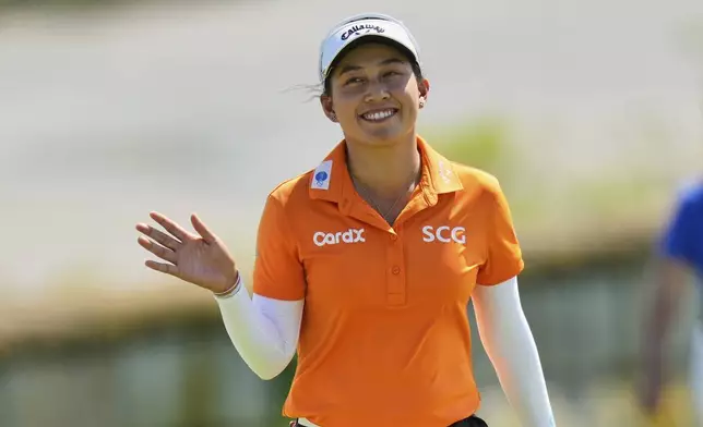 Jeeno Thitikul, of Thailand, waves as she arrives on the 18th green during the final round of the Mizuho Americas Open LPGA golf tournament, Sunday, May 11, 2025, in Jersey City, N.J. (AP Photo/Seth Wenig)
