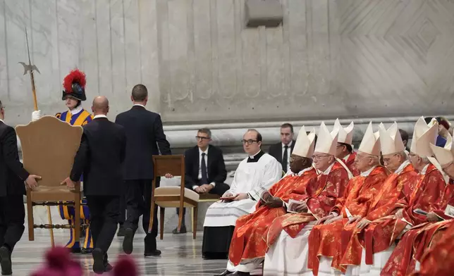 A chair is taken away at the end of a final Mass celebrated by cardinals inside St. Peter's Basilica, before the conclave to elect a new pope, at the Vatican, Wednesday, May 7, 2025. (AP Photo/Gregorio Borgia)