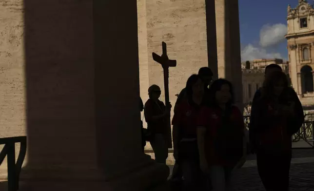 Pilgrims arrive to visit St. Peter's Basilica, at the Vatican, on Tuesday, May 6, 2025, the day before of the upcoming conclave starting on May 7, to elect the 267th Roman pontiff. (AP Photo/Francisco Seco)