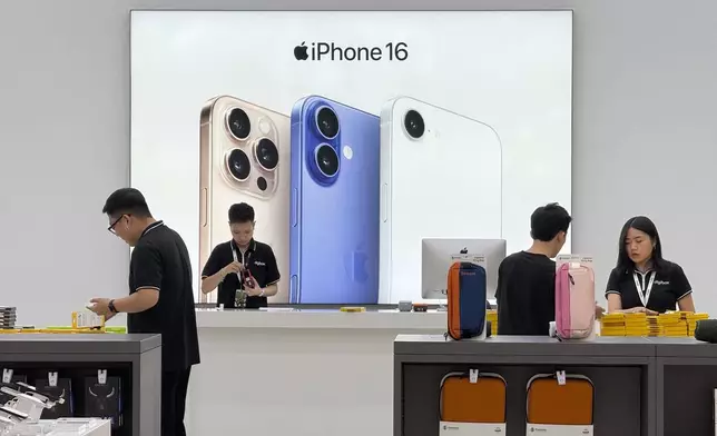 FILE - Sales staffs work at an Apple shop in Hanoi, Vietnam Thursday, April 10, 2025. (AP Photo/Hau Dinh, File)