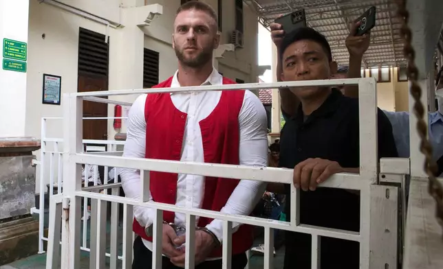 British citizen Thomas Parker, left, walks to a holding cell after he is sentenced for drug offenses, in Denpasar in Bali, Indonesia, Tuesday, May 27, 2025. (AP Photo/Firdia Lisnawati)