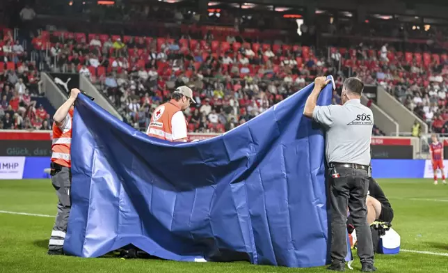 Heidenheim goalkeeper Kevin Müller is treated on the pitch during the Bundesliga soccer match between FC Heidenheim and VfL Bochum at Voith-Arena. Heidenheim, Germany, Friday May 2, 2025. (Harry Langer/dpa via AP)