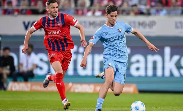 Heidenheim's Marvin Pieringer, left, and Bochum's Tim Oermann in action during the Bundesliga soccer match between FC Heidenheim and VfL Bochum at Voith-Arena. Heidenheim, Germany, Friday May 2, 2025. (Harry Langer/dpa via AP)