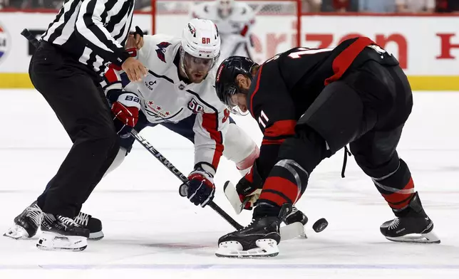 Washington Capitals' Pierre-Luc Dubois (80) faces off against Carolina Hurricanes' Jordan Staal (11) during the first period of Game 3 of an NHL hockey Semi-final round playoff series in Raleigh, N.C., Saturday, May 10, 2025. (AP Photo/Karl DeBlaker)