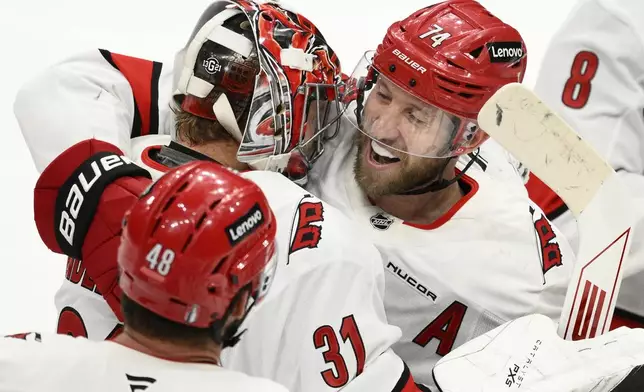 Carolina Hurricanes defenseman Jaccob Slavin (74) celebrates with goaltender Frederik Andersen (31) after Game 1 of a second-round NHL hockey playoff series against the Washington Capitals Tuesday, May 6, 2025, in Washington. (AP Photo/Nick Wass)