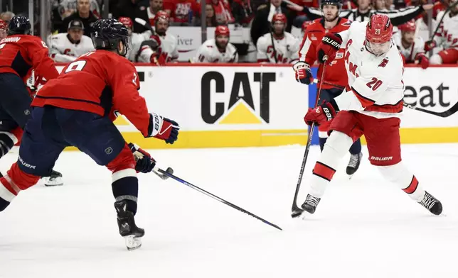 Carolina Hurricanes center Sebastian Aho (20) shoots the puck against Washington Capitals defenseman Matt Roy (3) in the second period of Game 2 of a second-round NHL hockey playoff series Thursday, May 8, 2025, in Washington. (AP Photo/Nick Wass)