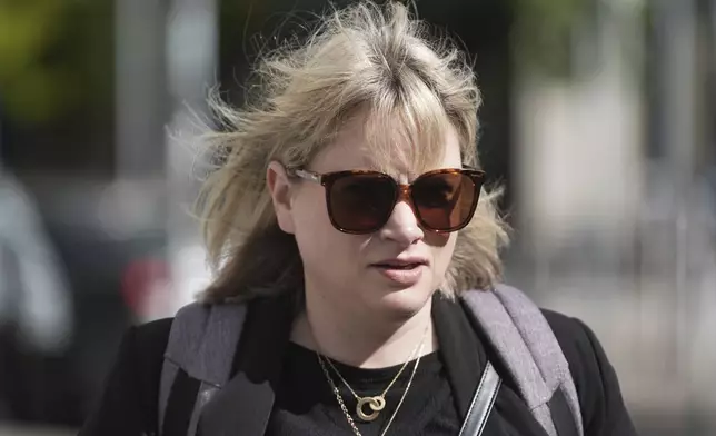 Producer Imelda Lynch walks outside the High Court where where former Sinn Fein president Gerry Adams is bringing a legal action against the BBC over allegations about the murder of an MI5 spy in 2006, in Dublin, Ireland, Wednesday May 28, 2025. (Brian Lawless/PA via AP)