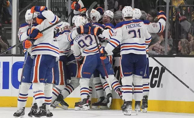 Edmonton Oilers right wing Kasperi Kapanen (42) celebrates with teammates after scoring against the Vegas Golden Knights during overtime of Game 5 of a second-round NHL hockey playoff series Wednesday, May 14, 2025, in Las Vegas. (AP Photo/John Locher)