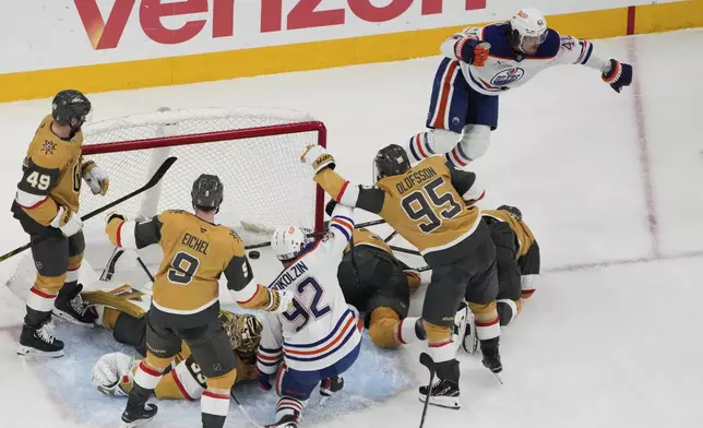 Edmonton Oilers right wing Kasperi Kapanen, upper right, celebrates after scoring against the Vegas Golden Knights during overtime of Game 5 of a second-round NHL hockey playoff series Wednesday, May 14, 2025, in Las Vegas. (AP Photo/John Locher)