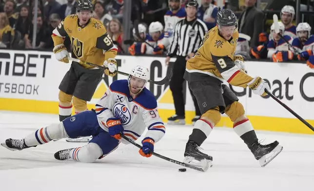 Edmonton Oilers center Connor McDavid (97) and Vegas Golden Knights center Jack Eichel (9) battle for the puck during the second period of Game 5 of a second-round NHL hockey playoff series Wednesday, May 14, 2025, in Las Vegas. (AP Photo/John Locher)