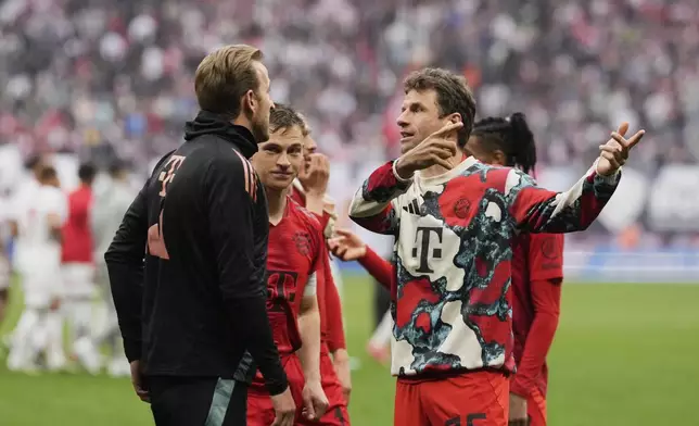 Bayern's Thomas Mueller speaks with teammate Harry Kane, left, on the pitch at the end of the German Bundesliga soccer match between RB Leipzig and FC Bayern Munich at the Red Bull Arena in Leipzig, Germany, Saturday, May 3, 2025. (AP Photo/Matthias Schrader)