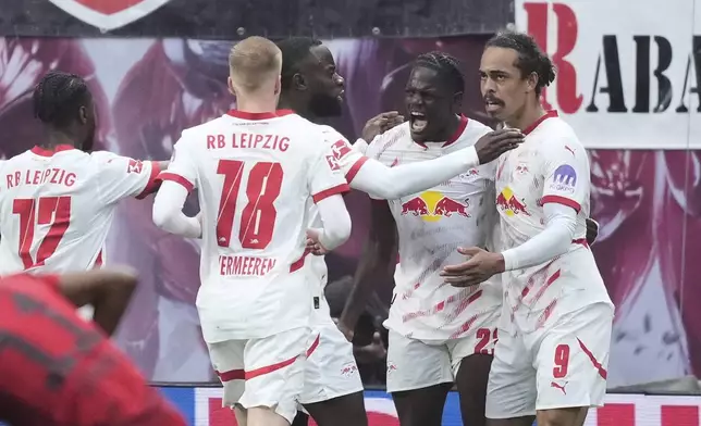 Leipzig's Yussuf Poulsen, right, celebrates with teammates after scoring his side's third goal during the German Bundesliga soccer match between RB Leipzig and FC Bayern Munich at the Red Bull Arena in Leipzig, Germany, Saturday, May 3, 2025. (AP Photo/Ebrahim Noroozi)
