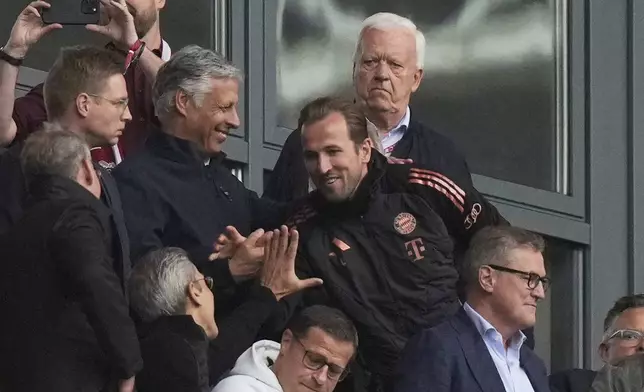 Bayern's Harry Kane, center, arrives on the tribune ahead of the German Bundesliga soccer match between RB Leipzig and FC Bayern Munich at the Red Bull Arena in Leipzig, Germany, Saturday, May 3, 2025. (AP Photo/Matthias Schrader)