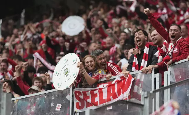 Bayern fans celebrate after Bayern's Leroy Sane scored his side's third goal during the German Bundesliga soccer match between RB Leipzig and FC Bayern Munich at the Red Bull Arena in Leipzig, Germany, Saturday, May 3, 2025. (AP Photo/Matthias Schrader)