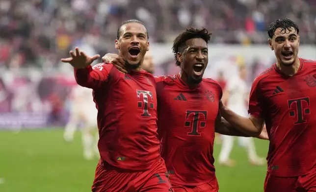Bayern's Leroy Sane, left, celebrates with Kingsley Coman, after scoring his side's third goal during the German Bundesliga soccer match between RB Leipzig and FC Bayern Munich at the Red Bull Arena in Leipzig, Germany, Saturday, May 3, 2025. (AP Photo/Matthias Schrader)
