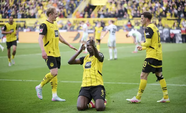 Dortmund's Serhou Guirassy, center, celebrates his goal with Julian Brandt, left and Pascal Groß, during the German Bundesliga soccer match between Borussia Dortmund and VfL Wolfsburg, at Signal Iduna Park, in Dortmund, Germany, Saturday, May 3, 2025. (Bernd Thissen/dpa via AP)