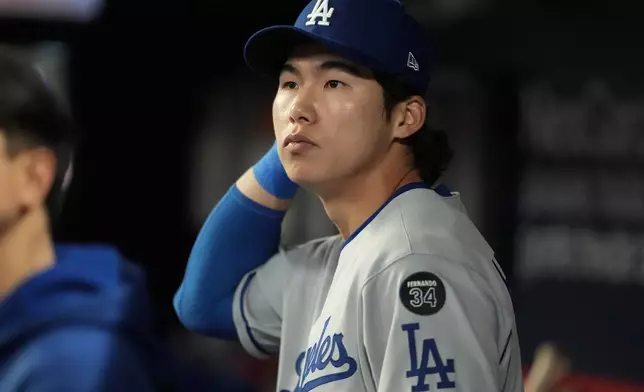 Los Angeles Dodgers' Hyeseong Kim stands in the dugout in the ninth inning of a baseball game against the Atlanta Braves, Sunday, May 4, 2025, in Atlanta. (AP Photo/Mike Stewart)