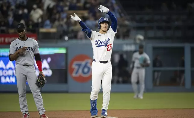 Los Angeles Dodgers' Tommy Edman, right, celebrates his two-run double during the sixth inning of a baseball game against the Miami Marlins in Los Angeles, Tuesday, April 29, 2025. (AP Photo/Kyusung Gong)