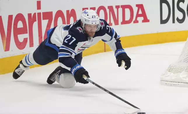 Winnipeg Jets' Nikolaj Ehlers dives to clear the puck in the second period of Game 3 of a second-round NHL hockey playoff series against the Dallas Stars in Dallas, Sunday, May 11, 2025. (AP Photo/Julio Cortez)