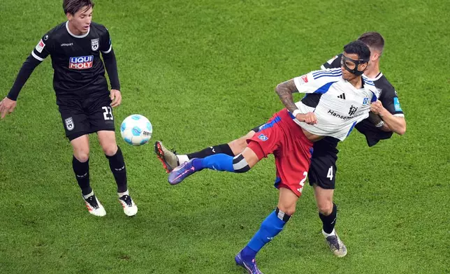 Hamburg's Davie Selke, center, fights for the ball against Ulm's Max Brandt, left, and Ulm's Tom Gaal during the soccer game between Hamburger SV and SSV Ulm 1846 in Hamburg, Germany, on Saturday, May 10, 2025. (Christian Charisius/dpa via AP)