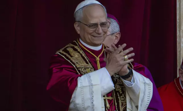 Newly elected Pope Leo XIV, left, formerly Cardinal Robert Francis Prevost, appears on the central loggia of St. Peter's Basilica at the Vatican shortly after his election as the 267th pontiff of the Roman Catholic Church, Thursday, May 8, 2025. (AP Photo/Domenico Stinellis)