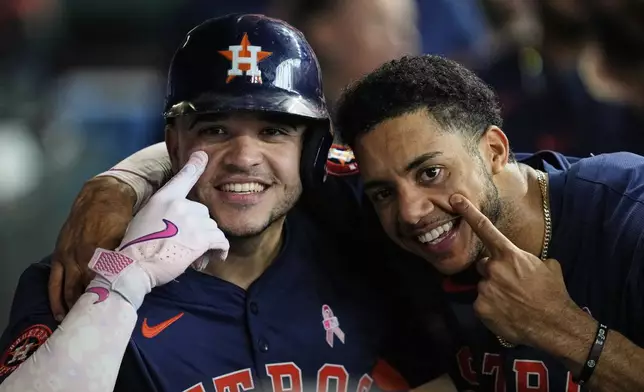 Houston Astros' Yainer Diaz, left, celebrates with Jeremy Pena after hitting a home run during the third inning of a baseball game against the Cincinnati Reds in Houston, Sunday, May 11, 2025. Isaac Paredes and Christian Walker also scored. (AP Photo/Ashley Landis)