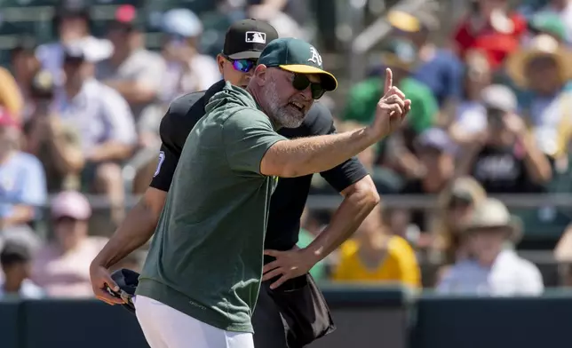 Athletics manager Mark Kotsay, front, argues with umpire Roberto Ortiz, back, after being ejected during the seventh inning of a baseball game against the Philadelphia Phillies, Sunday, May 25, 2025, in West Sacramento, Calif. (AP Photo/Sara Nevis)