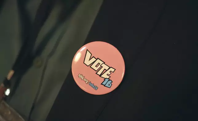 An attendee wears a pin during a Town Hall and voter registration for school board elections at the Bethany Baptist Church, Saturday, Feb. 1, 2025, in Newark, N.J. (AP Photo/Andres Kudacki)