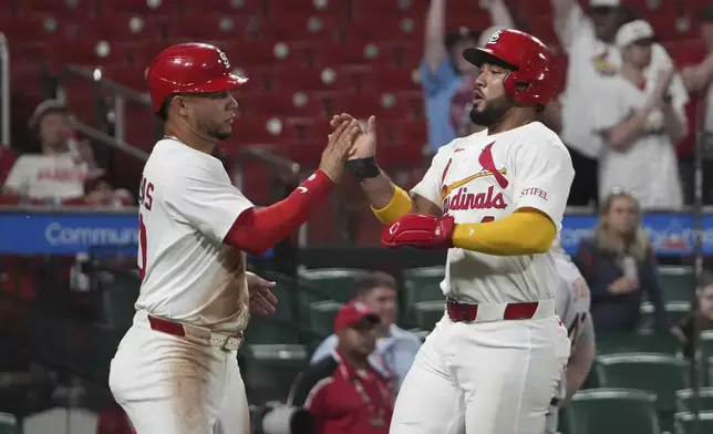 St. Louis Cardinals' Ivan Herrera, right and Willson Contreras celebrate after scoring during the seventh inning of a baseball game against the Detroit Tigers Monday, May 19, 2025, in St. Louis. (AP Photo/Jeff Roberson)