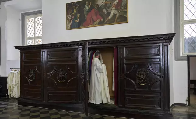 A priest removes his chasuble in the sacristy of Santa Maria ai Monti Church after Mass in Rome, Sunday, May 4, 2025. (AP Photo/Bernat Armangue)
