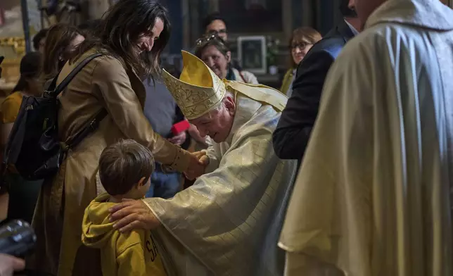 Cardinal Jean-Marc Aveline, center, greets faithful after a mass at Santa Maria ai Monti church in Rome, Sunday, May 4, 2025. (AP Photo/Bernat Armangue)