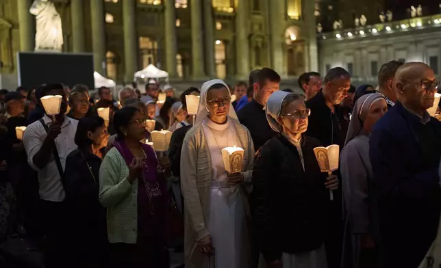 Faithful gather for a rosary prayer and a candlelight procession with the image of Mater Ecclesiae in St. Peter's Square at the Vatican,Saturday, May 3, 2025. (AP Photo/Bernat Armangue)