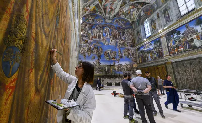 In this image taken on Wednesday, April 30, 2025, and made available Saturday, May 3, 2025, by Vatican Media, workers and restorers prepare the Sistine Chapel at the Vatican, where the upcoming conclave will start May 7. (Vatican Media via AP)