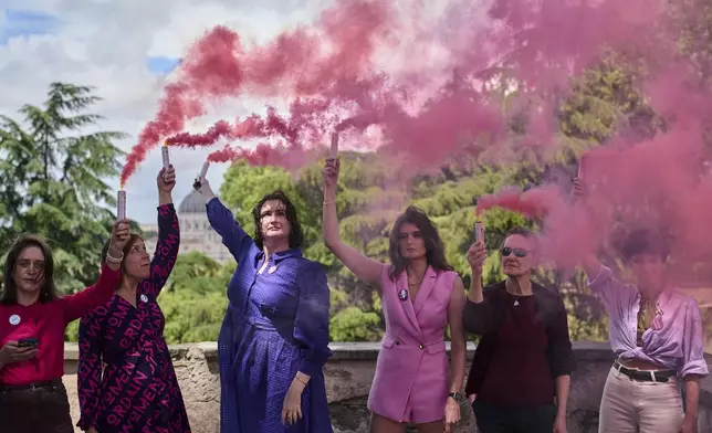 Activists from the Women's Ordination Conference release pink smoke to call for full equality for women in the Catholic Church on the first day of the conclave to elect the 267th pope, in Rome, Wednesday, May 7, 2025. (AP Photo/Bernat Armangue)