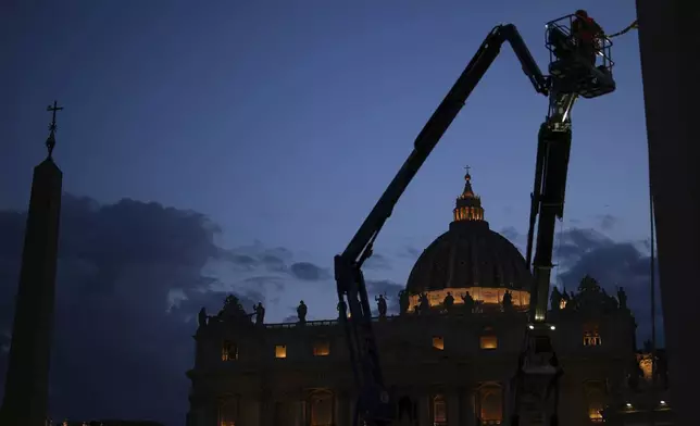 Workers install sound system speakers in St. Peter's Square, at the Vatican, on Monday, May 5, 2025, ahead of the upcoming conclave starting on May 7, to elect the 267th Roman pontiff. (AP Photo/Francisco Seco)