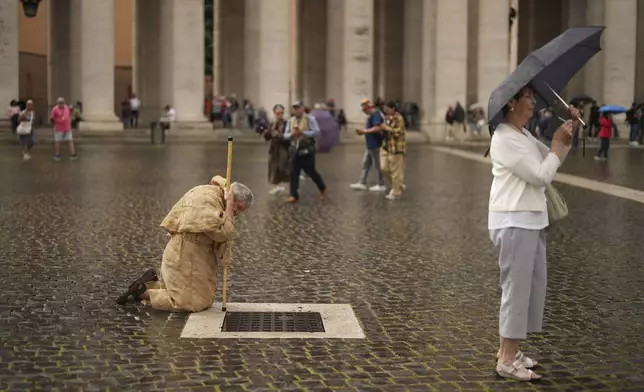 A faithful prays in St. Peter's Square during a final Mass by cardinals ahead of the conclave, at the Vatican, Wednesday, May 7, 2025. (AP Photo/Francisco Seco)