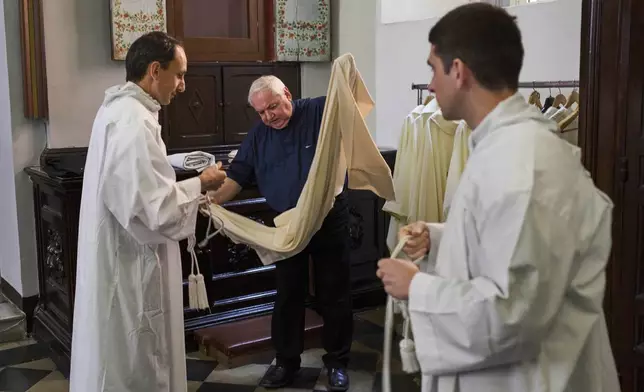 Cardinal Jean-Marc Aveline, center, prepares in the sacristy of Santa Maria ai Monti church before celebrating Mass in Rome, Sunday, May 4, 2025. (AP Photo/Bernat Armangue)
