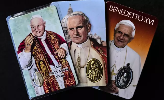 From left to right: religious memorabilia depicting Pope John XXIII, John Paul II and Pope Benedict XVI in Rome, Thursday, May 1, 2025. (AP Photo/Bernat Armangue)