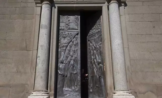An image of the cardinals who voted in the longest conclave in the Catholic Church's history, is carved on the bronze door of St. Lorenzo Cathedral, in Viterbo, Italy, Friday, May 2, 2025. (AP Photo/Alessandra Tarantino )