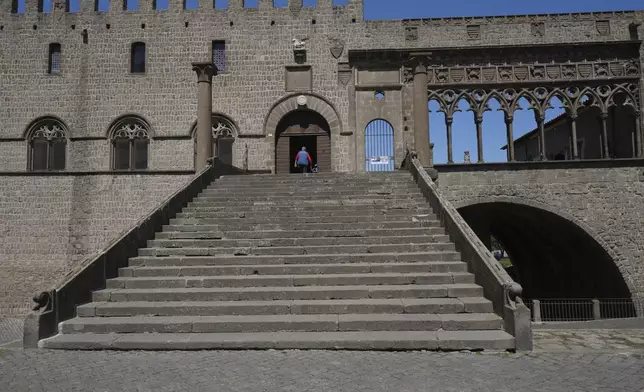 A tourist enters the Palace of the Popes that hosted the longest conclave in the Catholic Church's history, in Viterbo, Italy, Tuesday, April 29, 2025. (AP Photo/Alessandra Tarantino )